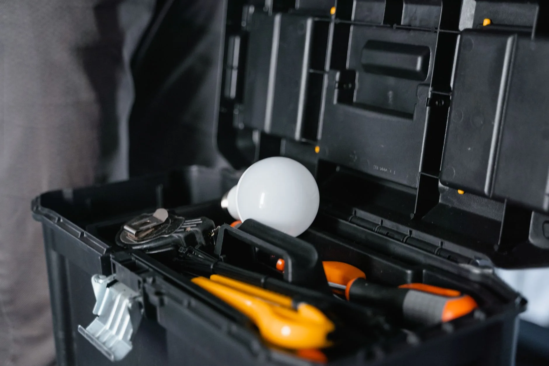 Boîte à outils ouverte avec ampoule et tournevis pour l'entretien de la maison